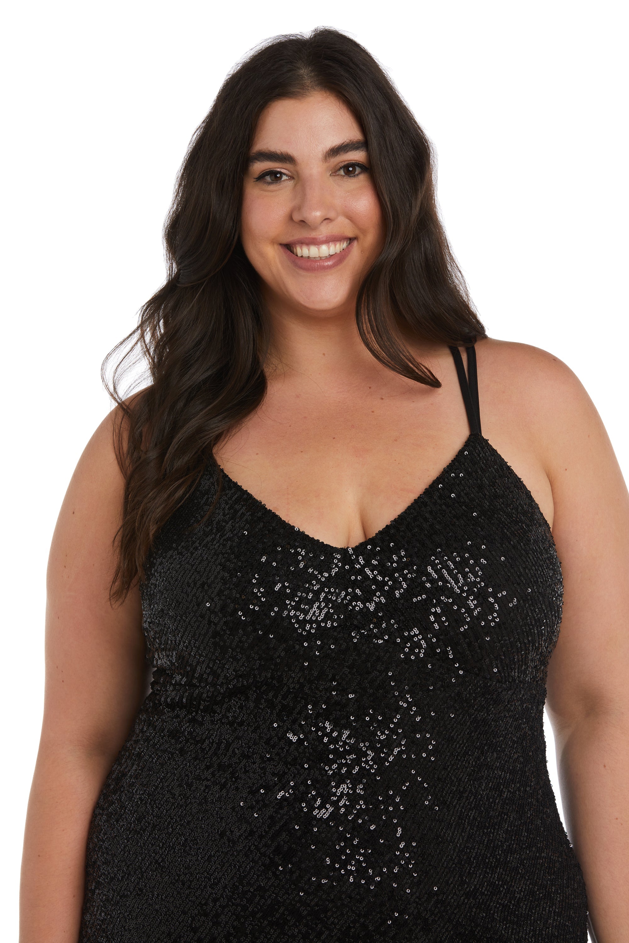 A woman with long dark hair smiles in the Morgan 13029WM, a plus-size sequin prom dress featuring a v-neckline and spaghetti straps, set against a plain white background.